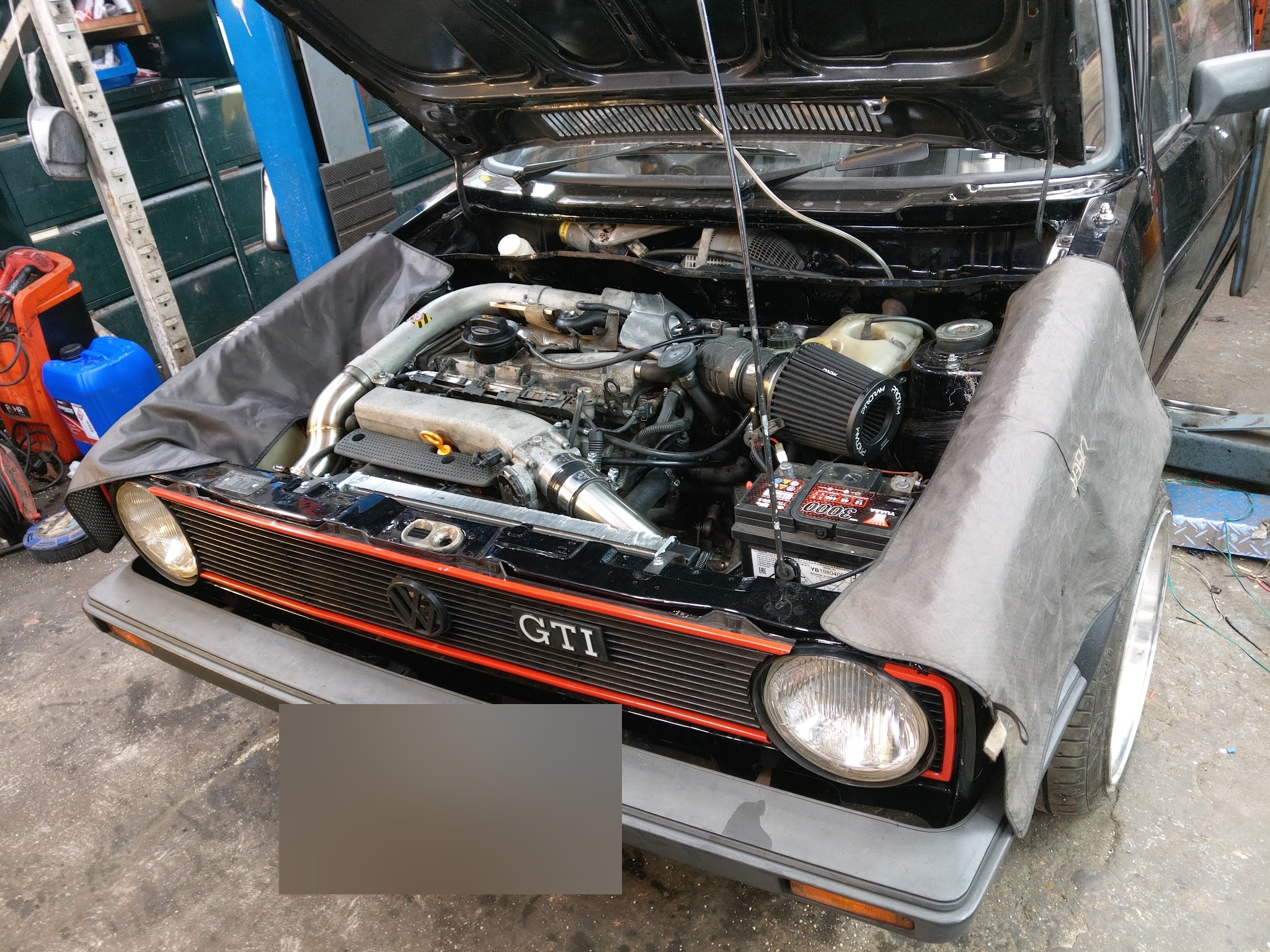 Black Mk1 GTI with wing covers on and a 1.8 turbo engine going in