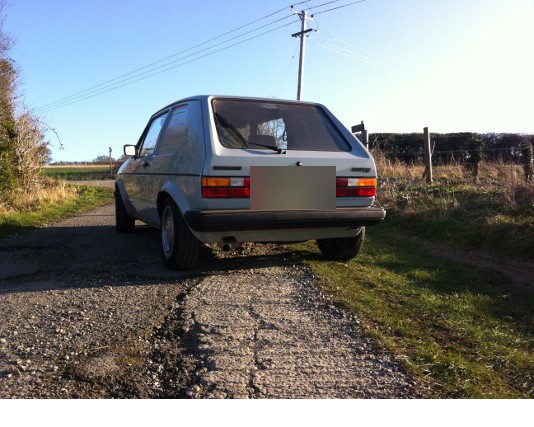 Silver Mk1 GTI on a country track, from behind